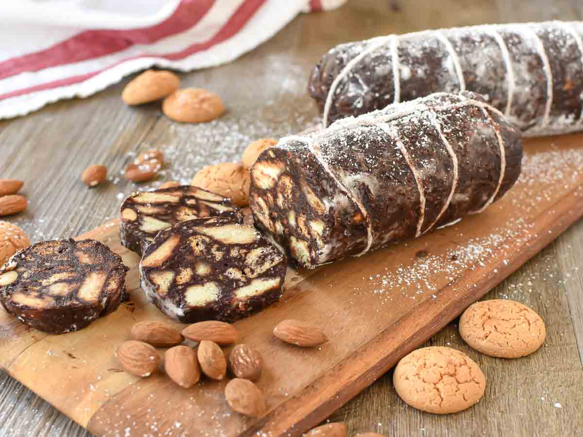 Two  chocolate logs that look like salami with few slices cut.