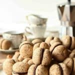 Pile of chocolate sandwiched hazelnut cookies on a white plate