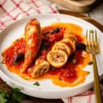 Stuffed Squid in tomato sauce on a plate, one whole and one sliced.