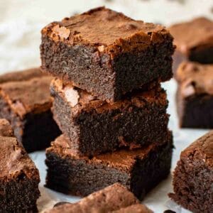 Three espresso brownies stacked with more brownies around.