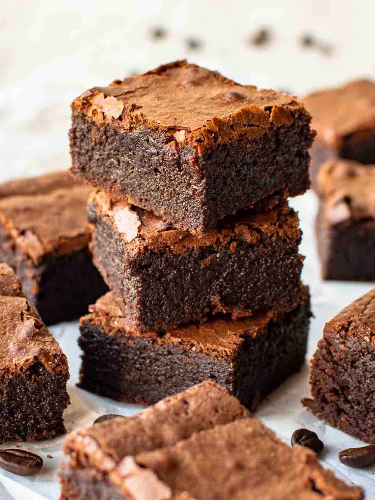 Three espresso brownies stacked with more brownies around.