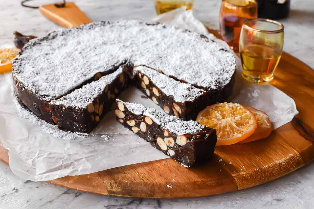 round cake of chocolate and nut confection with a few slices cut.