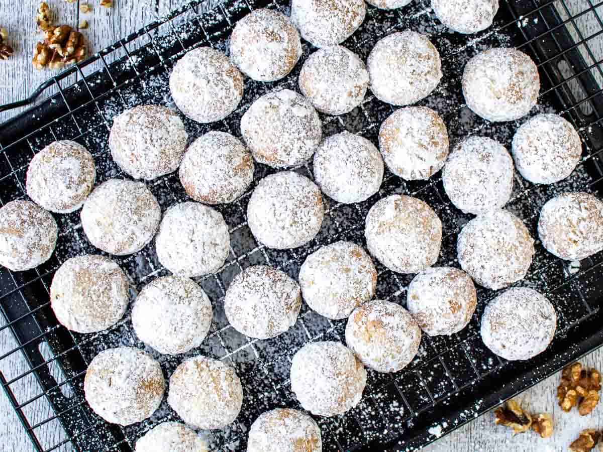 White sugar coated cookies on black wire rack viewed from above.
