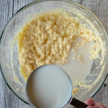 Milk being added to batter from a cup.