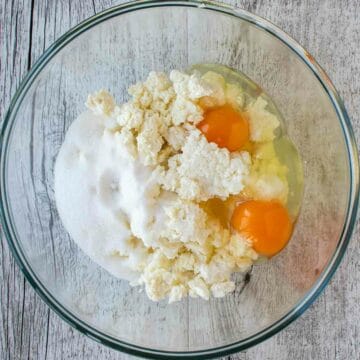 Eggs, sugar and ricotta in a bowl.