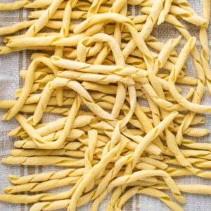 Busiate pasta on a kitchen towel viewed from above.