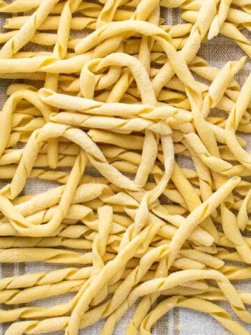 Busiate pasta on a kitchen towel viewed from above.