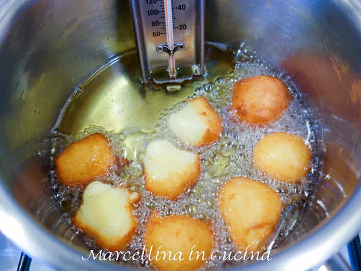 dough balls frying in hot oil.
