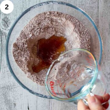 Water being poured into a bowl of cookie ingredients.