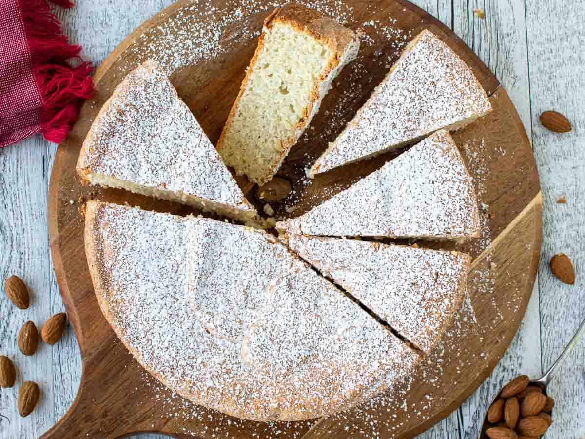 Overhead view of a round cake with five wedges cut. One wedge lying on it's side.