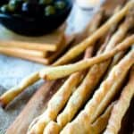 Bunch of grissini breadstick on wooden board.