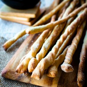 Bunch of grissini breadstick on wooden board.