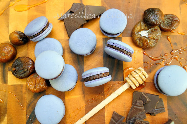 Finished Italian macarons on a table with chocolate and figs