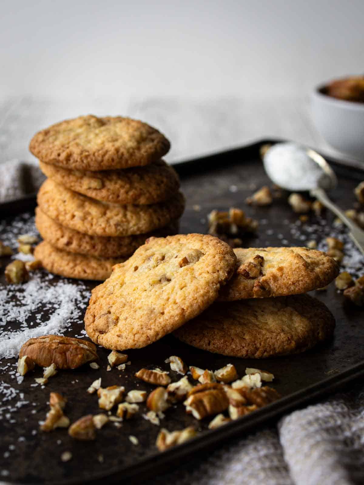 Coconut Pecan Cookies piled up onto a baking sheet.