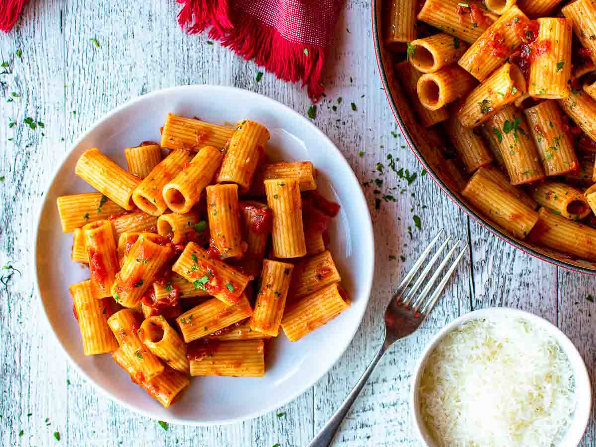 Pasta with tomato sauce on a white plate viewed from above.