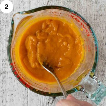 Pumpkin puree and other wet ingredients being mixed in a jug.