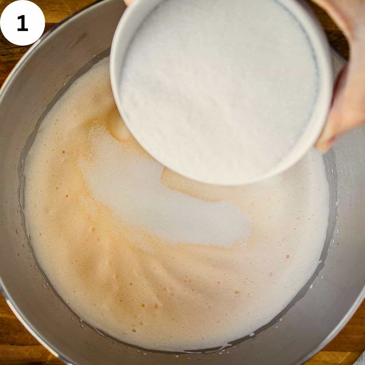 Pouring sugar into whipped egg mixture.