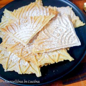 pile of wafer cookies on black plate.