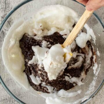 Whisked egg whites being mixed into chocolate.