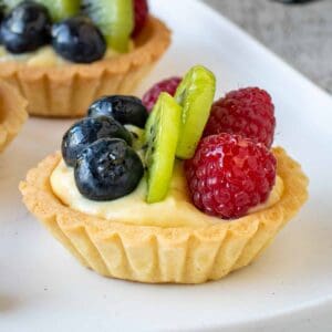 Mini fruit tarts on a white plate.