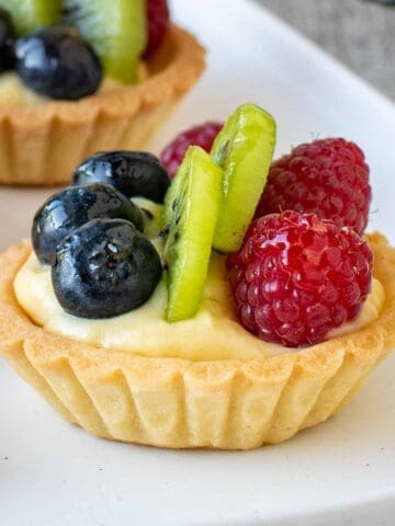 Mini fruit tarts on a white plate.