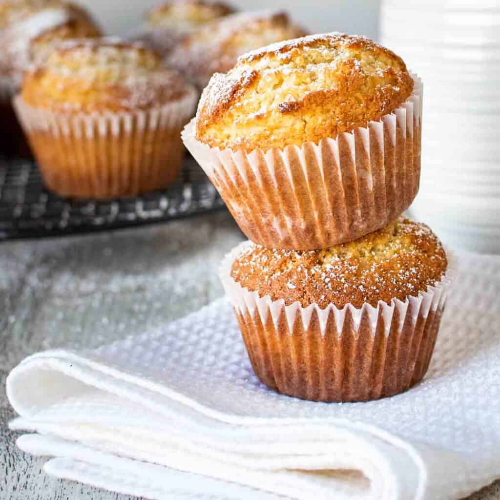 Two vanilla muffins stacked one on top of the other.