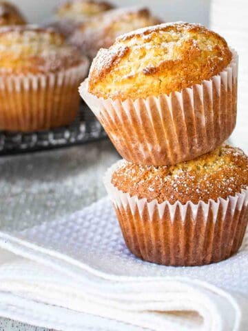 Two vanilla muffins stacked one on top of the other.