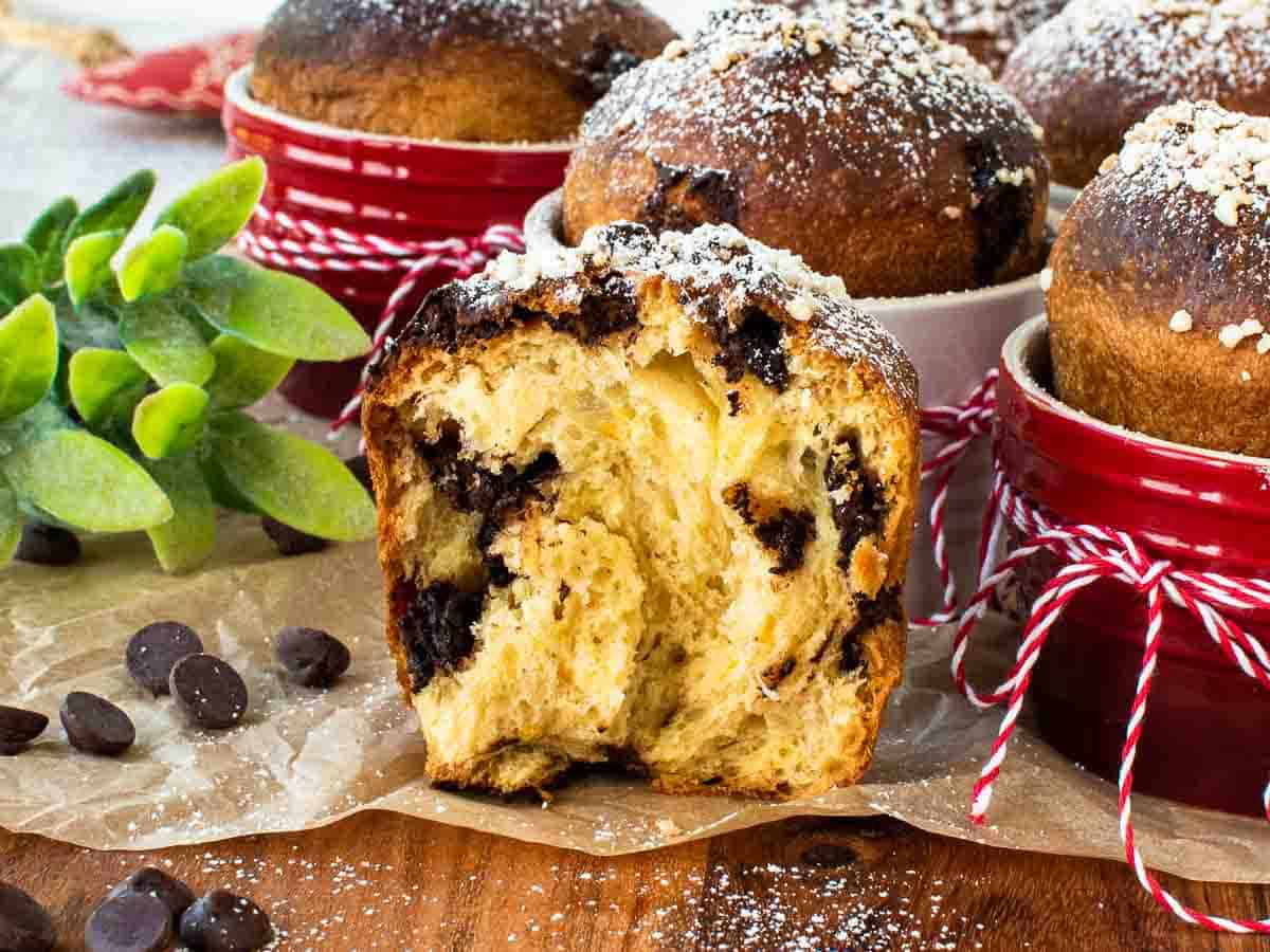 Close up of small bun broken in half showing chocolate chips inside.