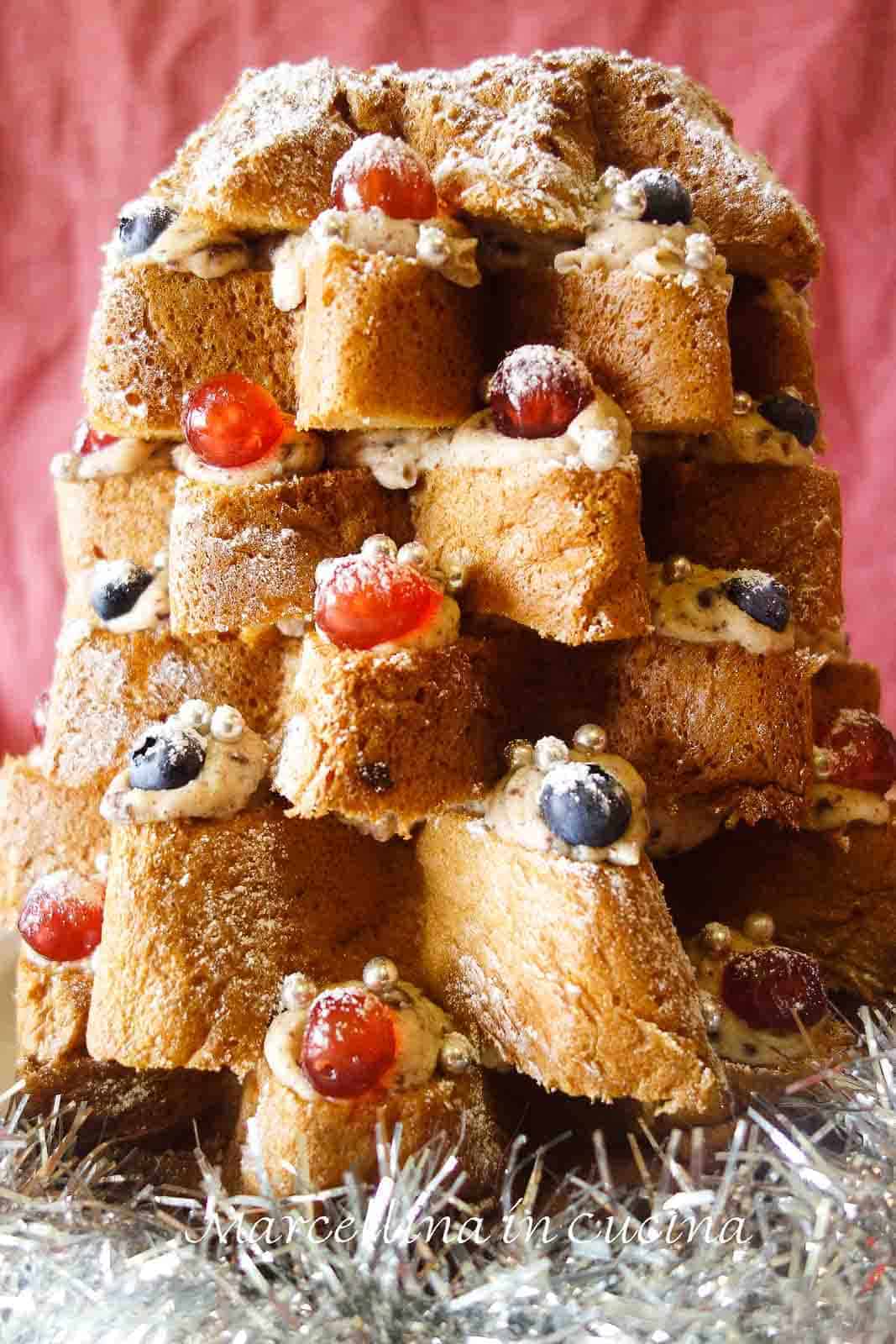 christmas tree cake with layers of cream filling, decorated with cherries and chocolate