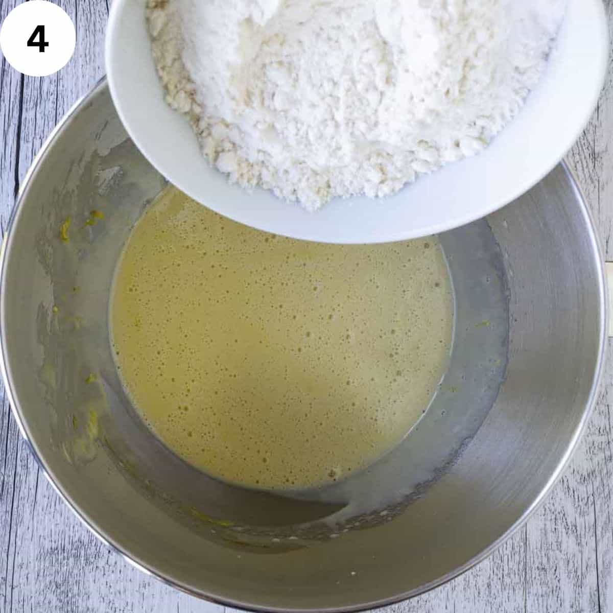 Adding flour to yellow frothy batter.