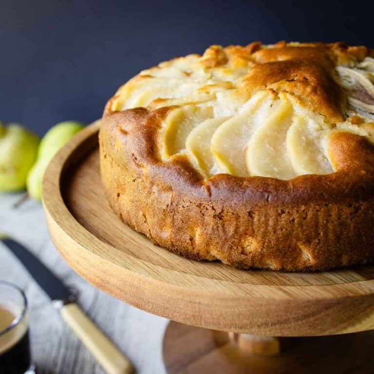 Italian Pear Cake on a wooden cake stand.