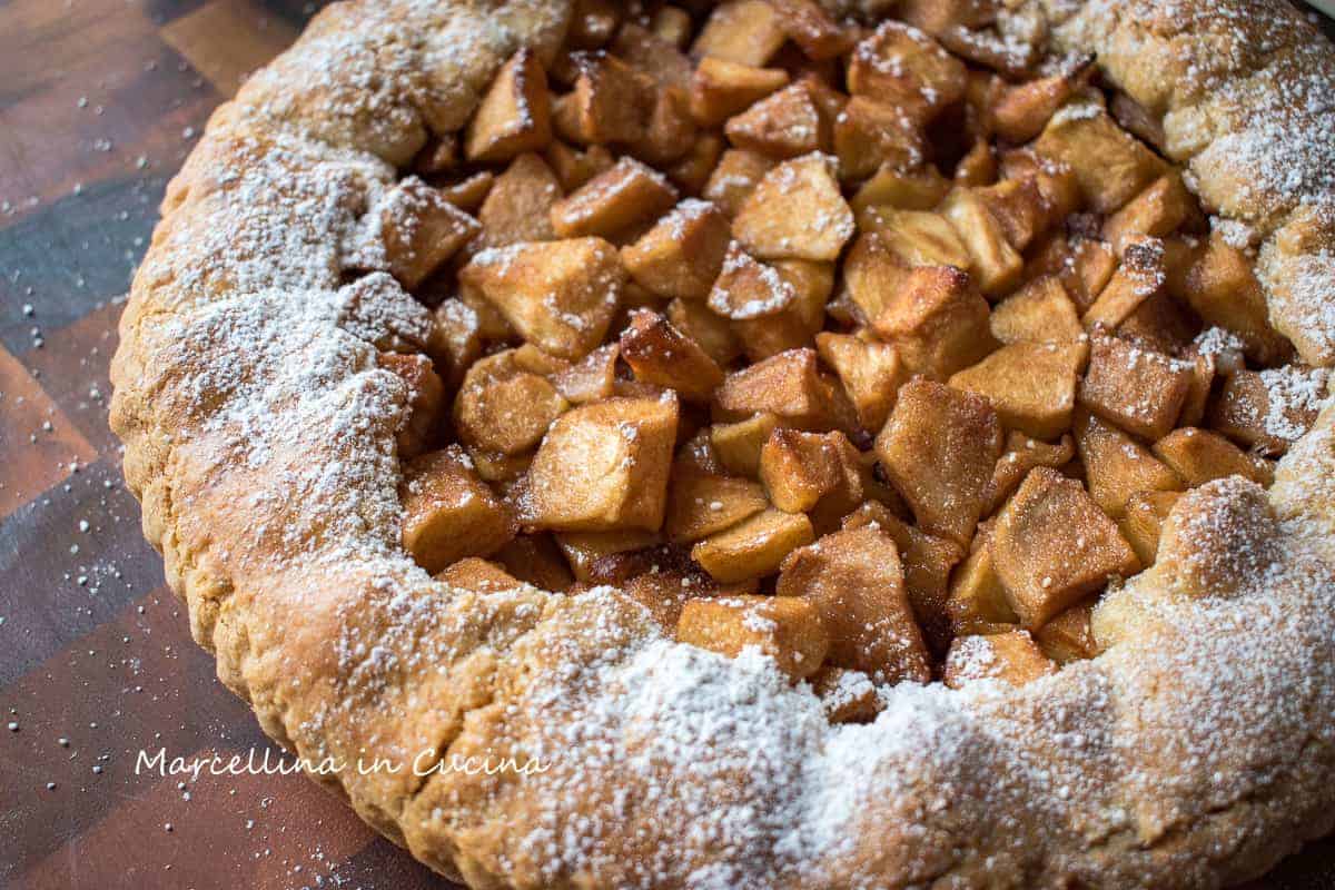 Close up of italian crostata with apple filling dusted with powdered sugar.