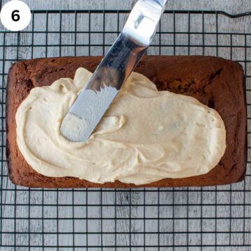 Creamy frosting being spread on a loaf cake.