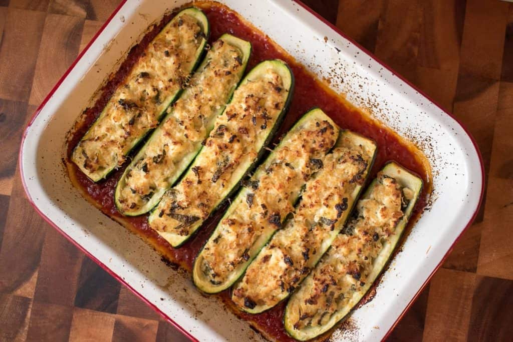 Baking tray with six Stuffed Zucchini halves with Ricotta in tomato sauce