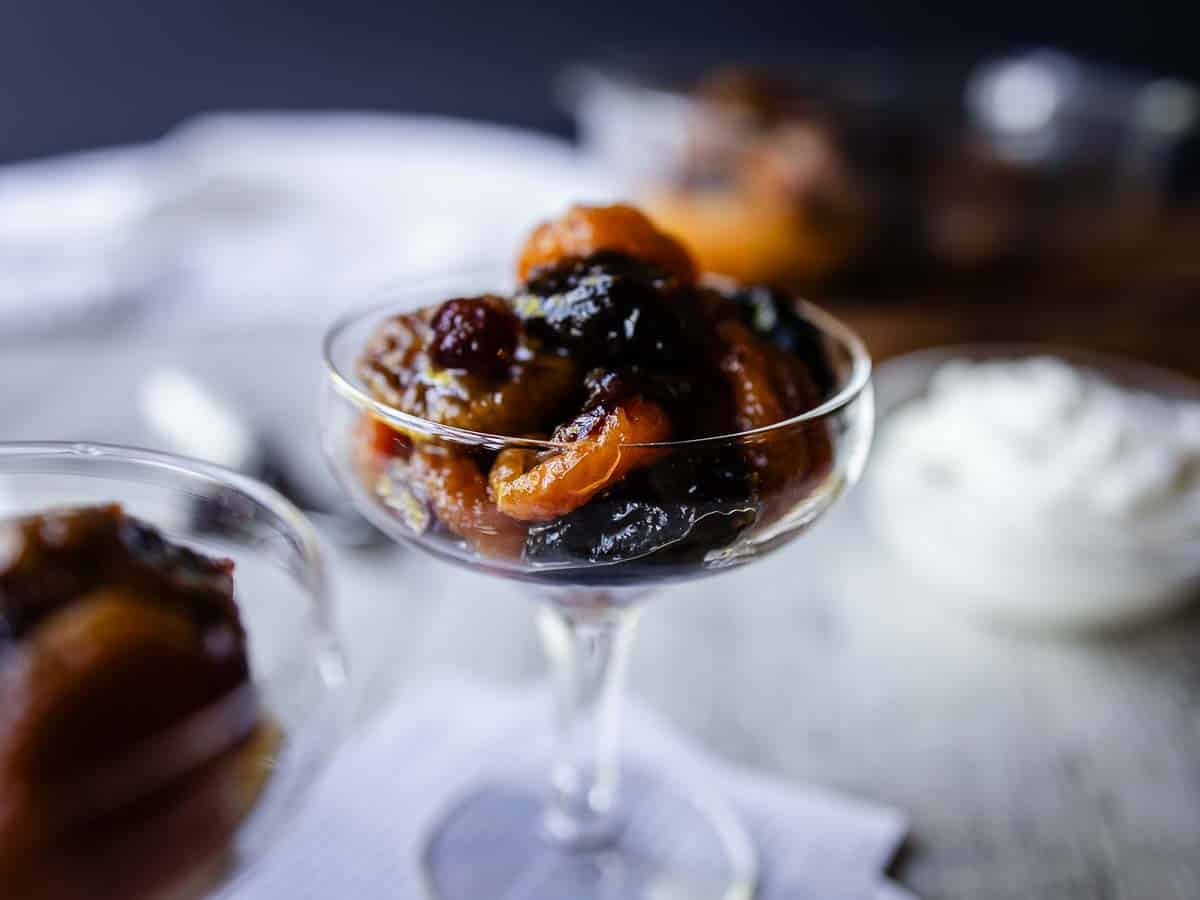 Close up of cooked dried fruit in a coupe glass.