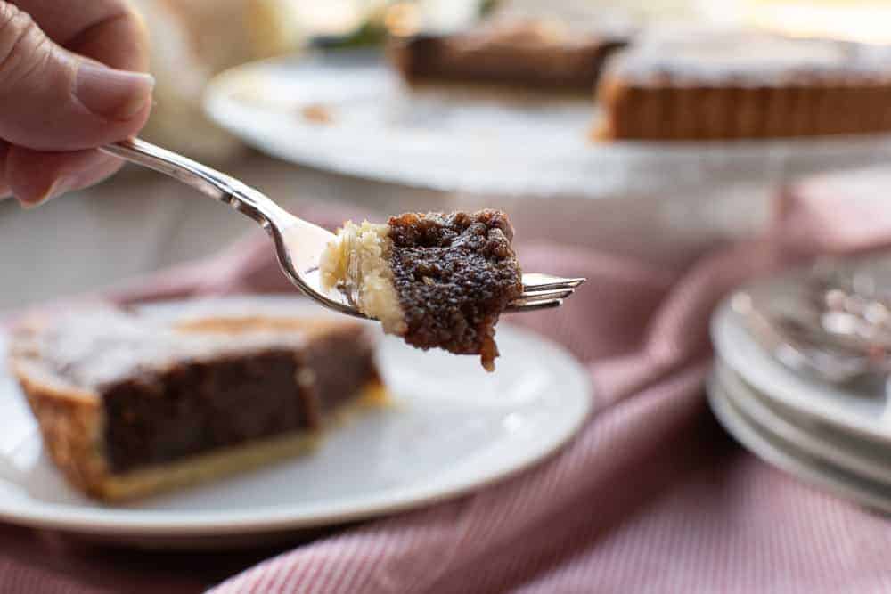 Slice of Chocolate, Hazelnut and Pear Tart with whole tart in background