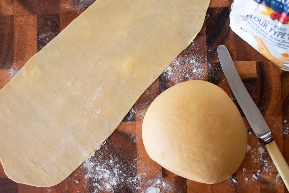 Pasta dough, rolled sheet of pasta, knife and flour.