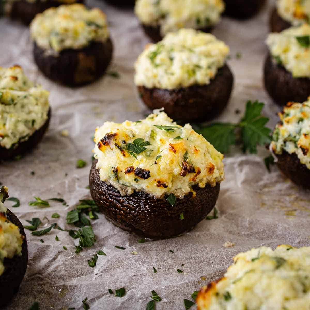 Ricotta stuffed mushrooms arranged on parchment paper.