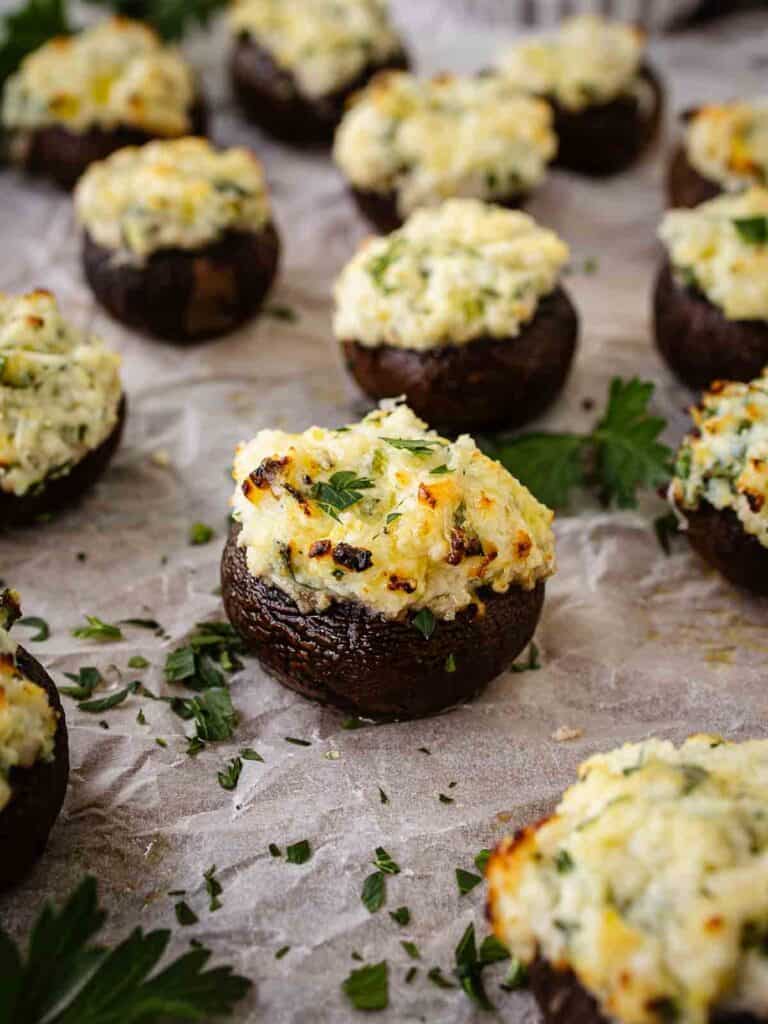 Ricotta stuffed mushrooms arranged on parchment paper.