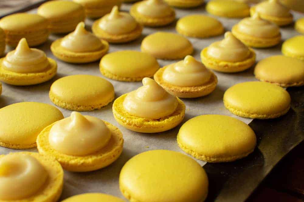 Yellow macarons halves topped with lemon filling