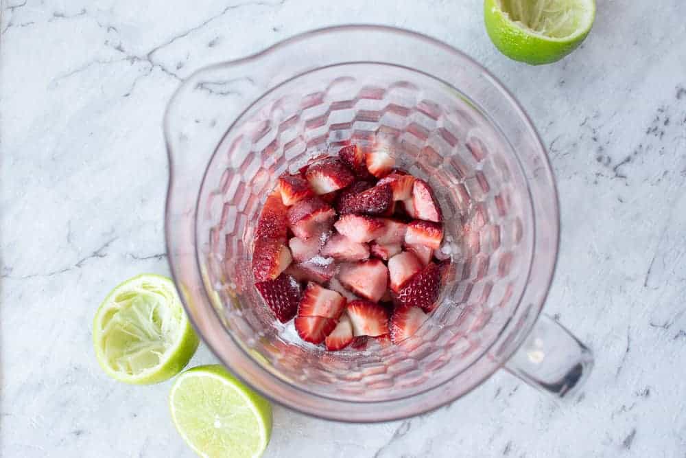 Chopped strawberries in a clear jug with Squeezed limes