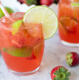 Glass of Strawberry Lime Water with strawberries and second glass behind