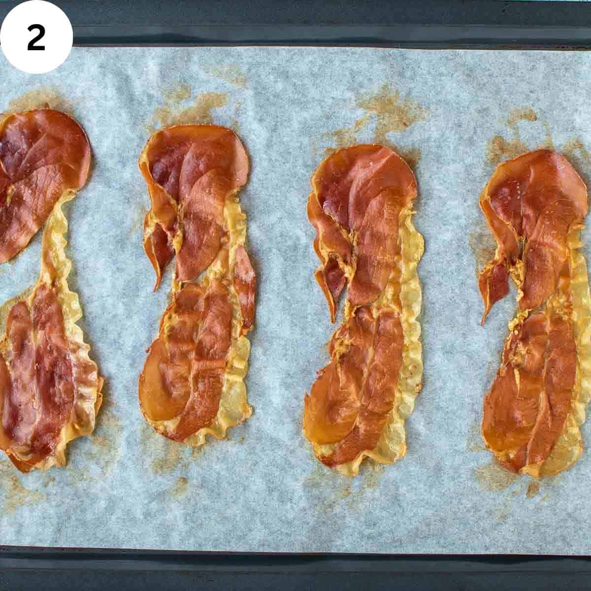 Cooked slices of prosciutto on parchment paper.
