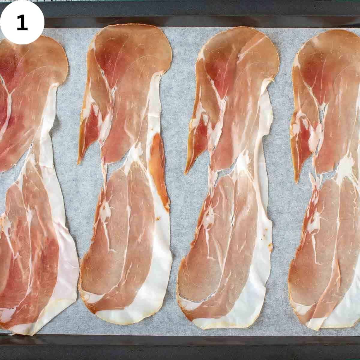 Slices of prosciutto on a parchment paper.