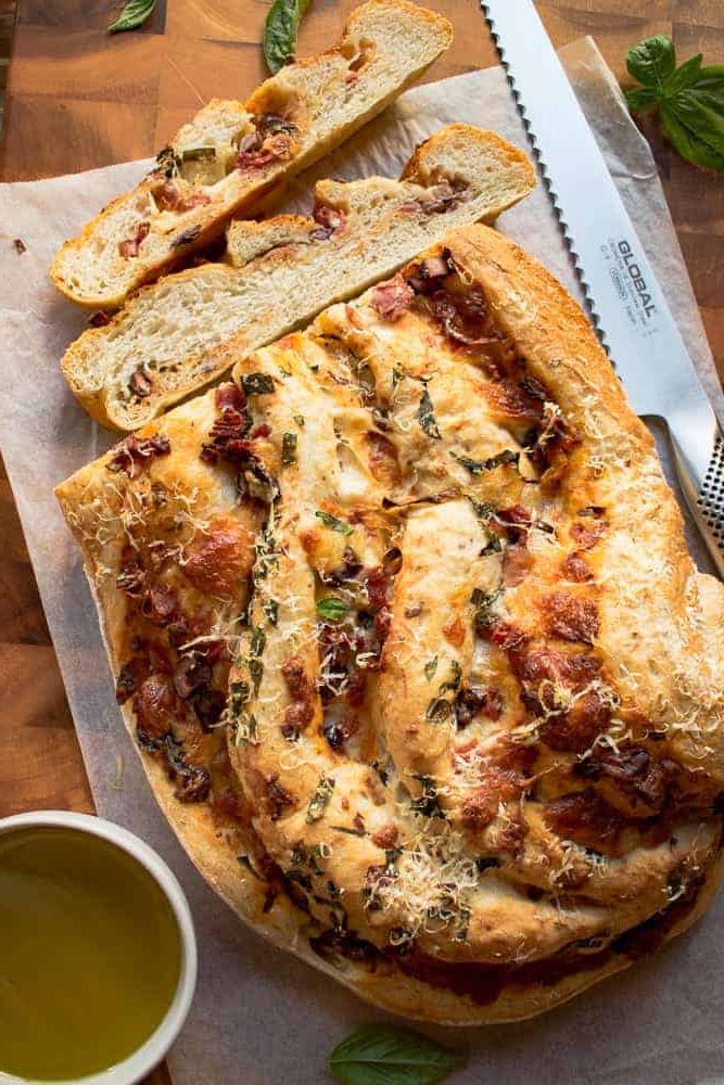 Finished pizza bread recipe with two slices cut.