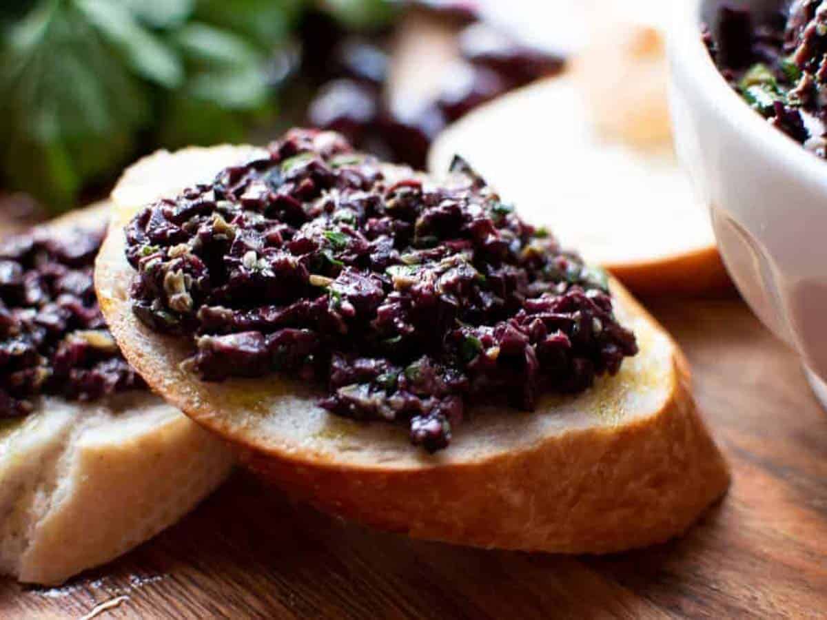 black chunky spread on oval slice of bread.