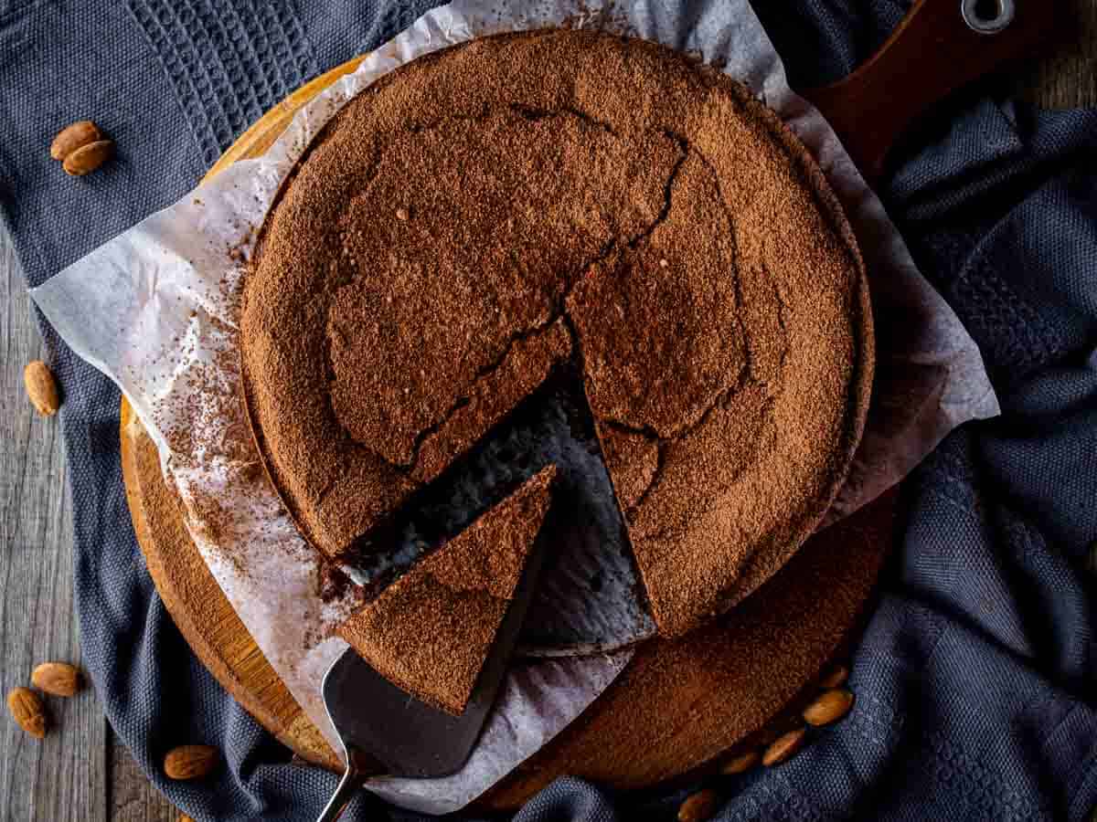 Round unfrosted chocolate cake with a wedge slightly removed viewed from above.