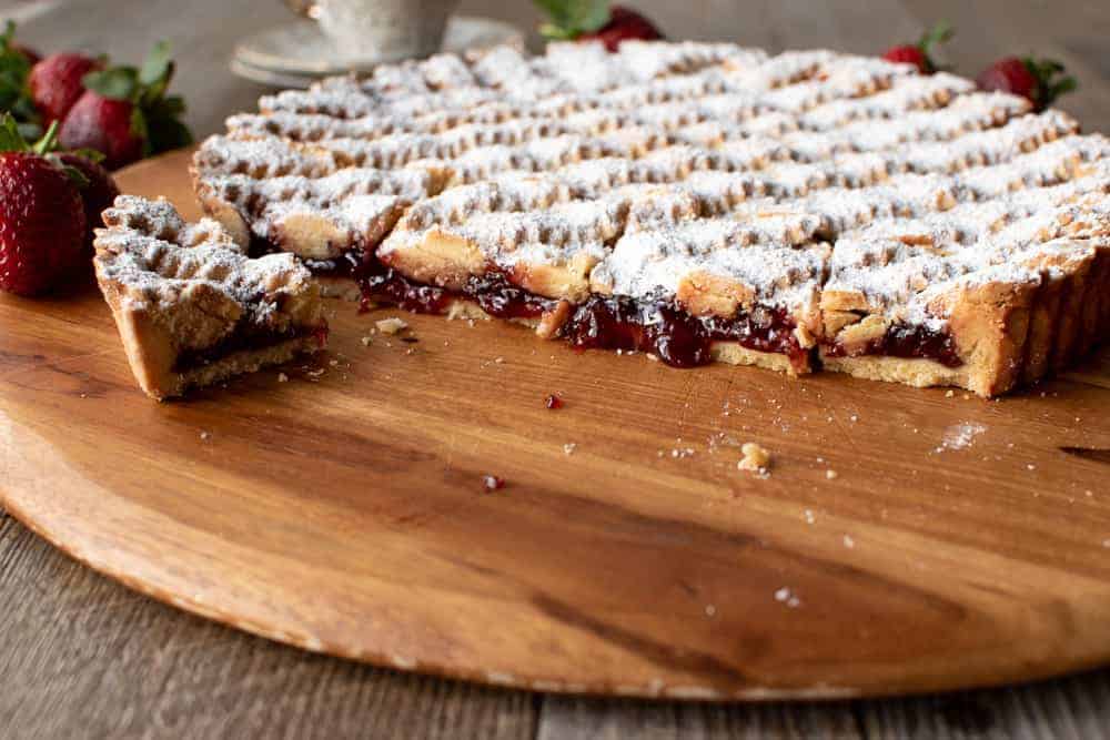 Strawberry crostata recipe cut with jam oozing.