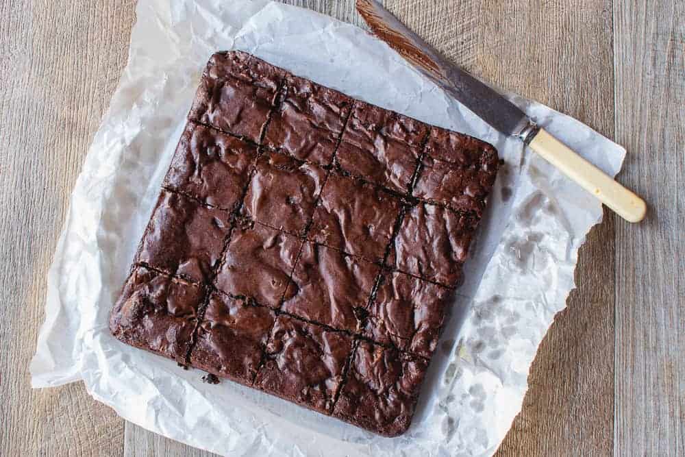 The brownies shown on baking paper from above, ready to be cut into squares