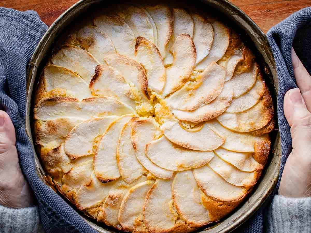 Overhead view of a baked cake topped with apple slices.